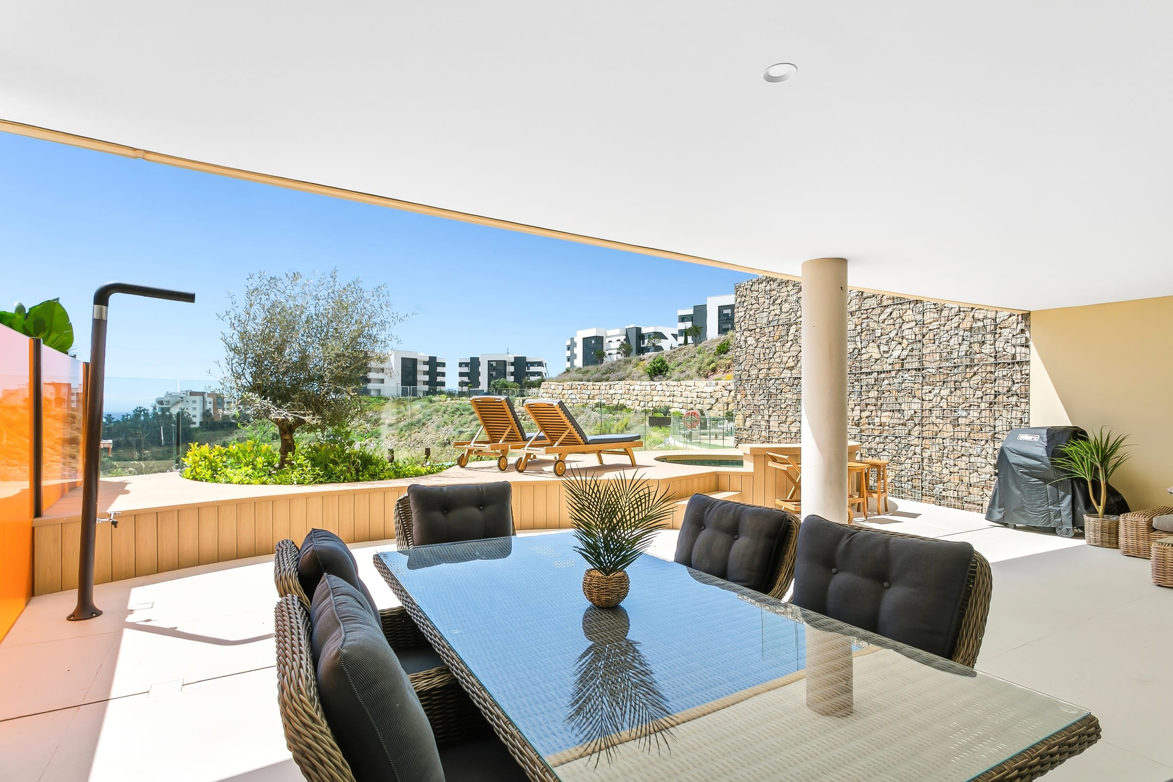 Overbygd terrasse med spisebord, hage og solsenger i en utleiebolig vi forvalter